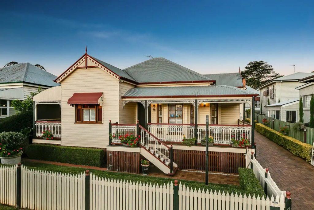 Cottage house front photo with gated lot zoom out view