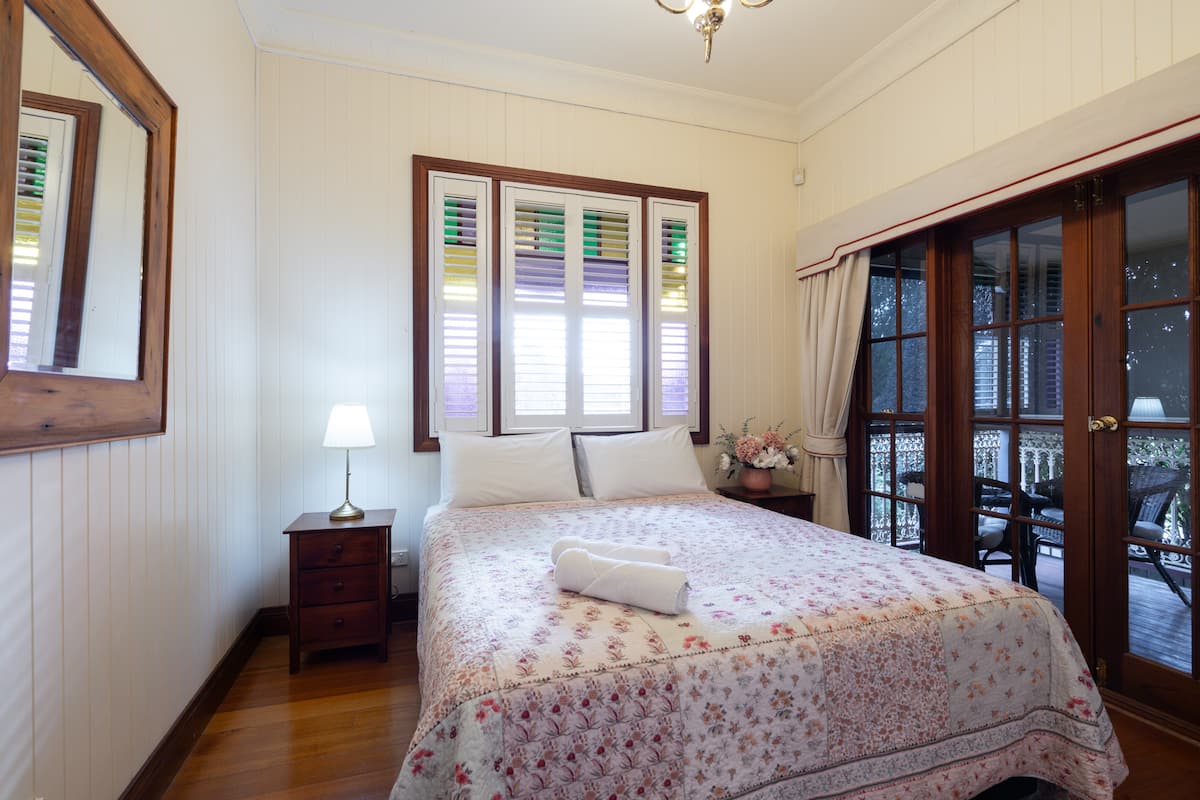 Cottage bedroom with French doors opening onto the verandah