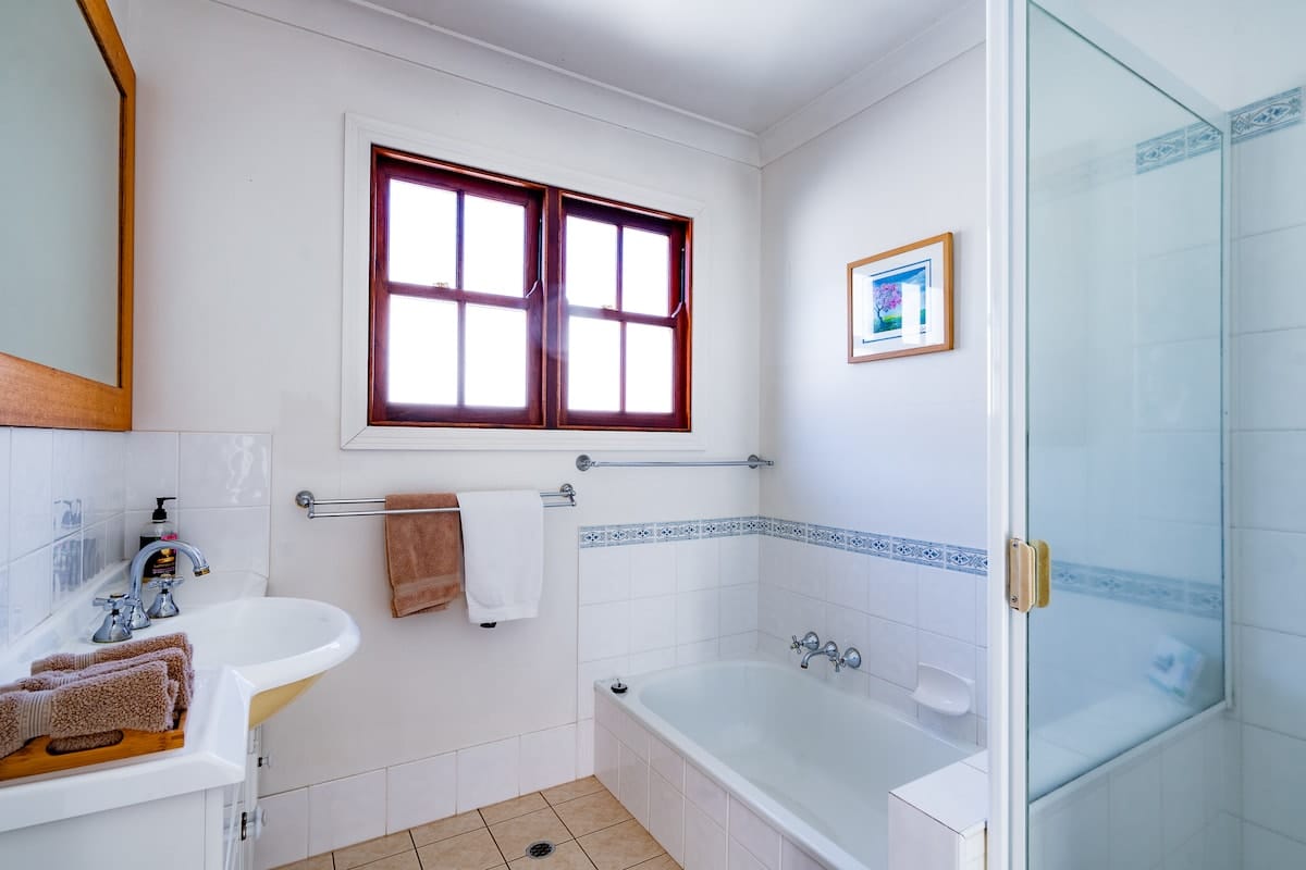 Lodge bathroom with bath, shower and timber-framed window