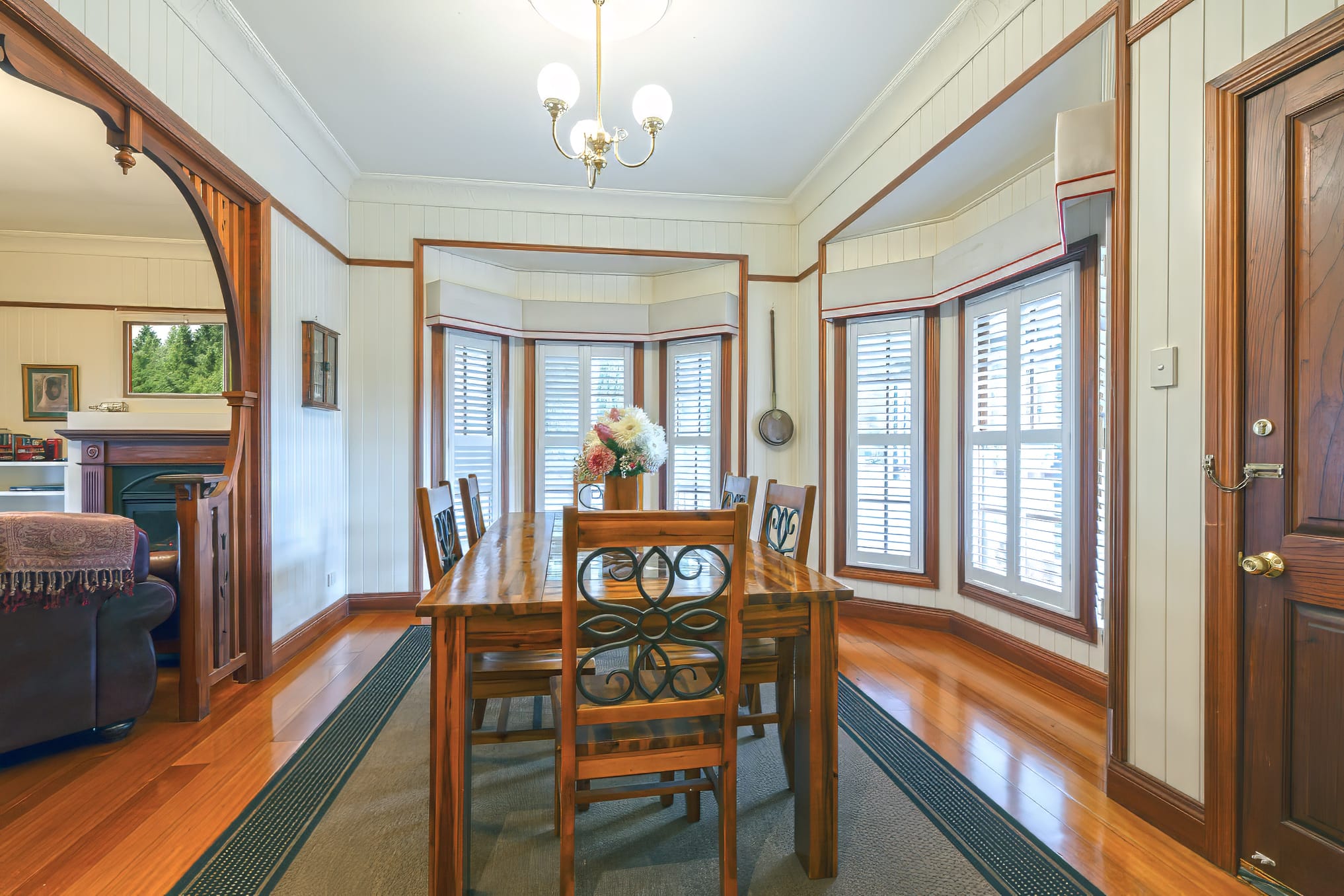 Cottage dining room with chandelier and bay window